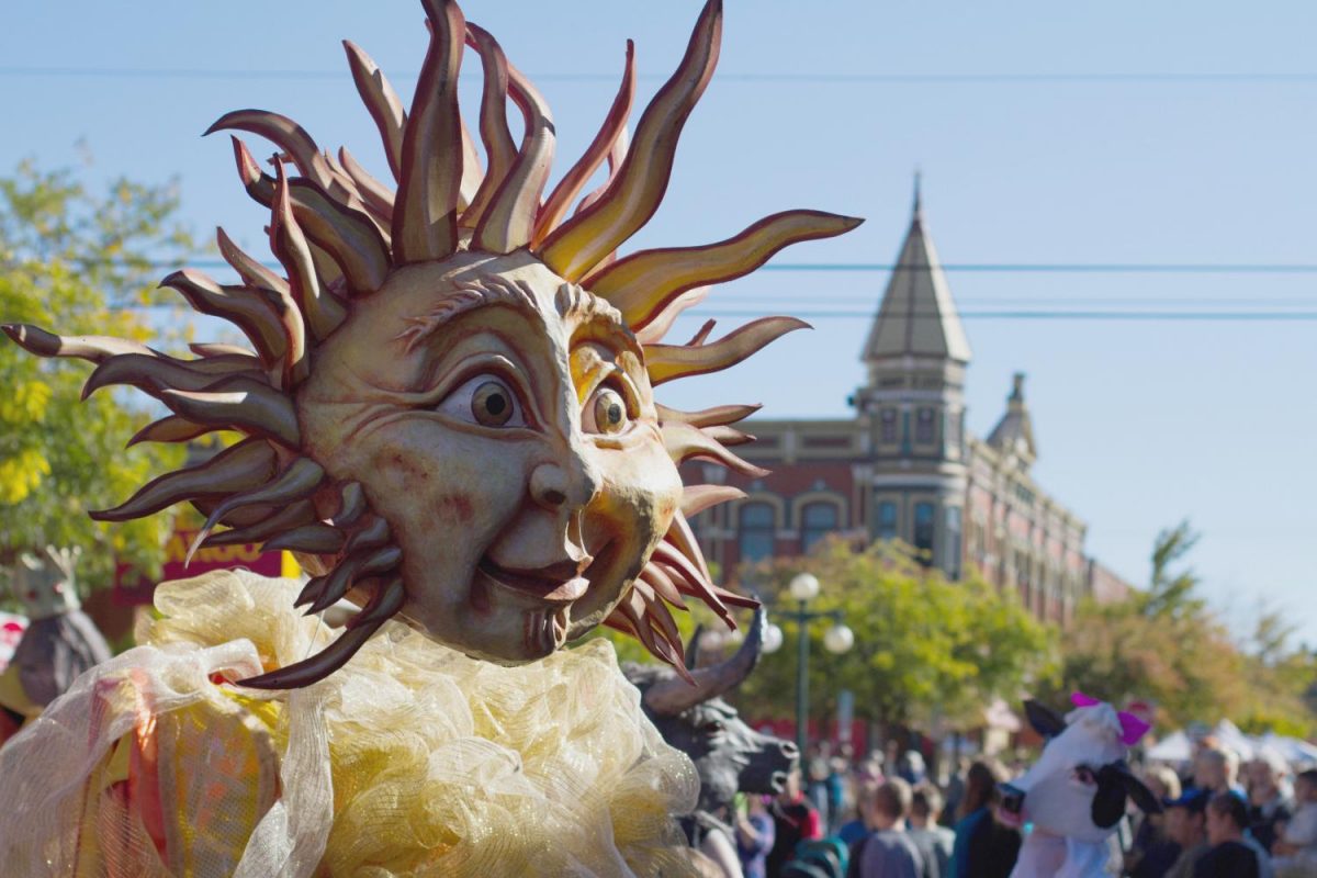 The sun head body puppeteer walks in the Arts Parade during the festival.