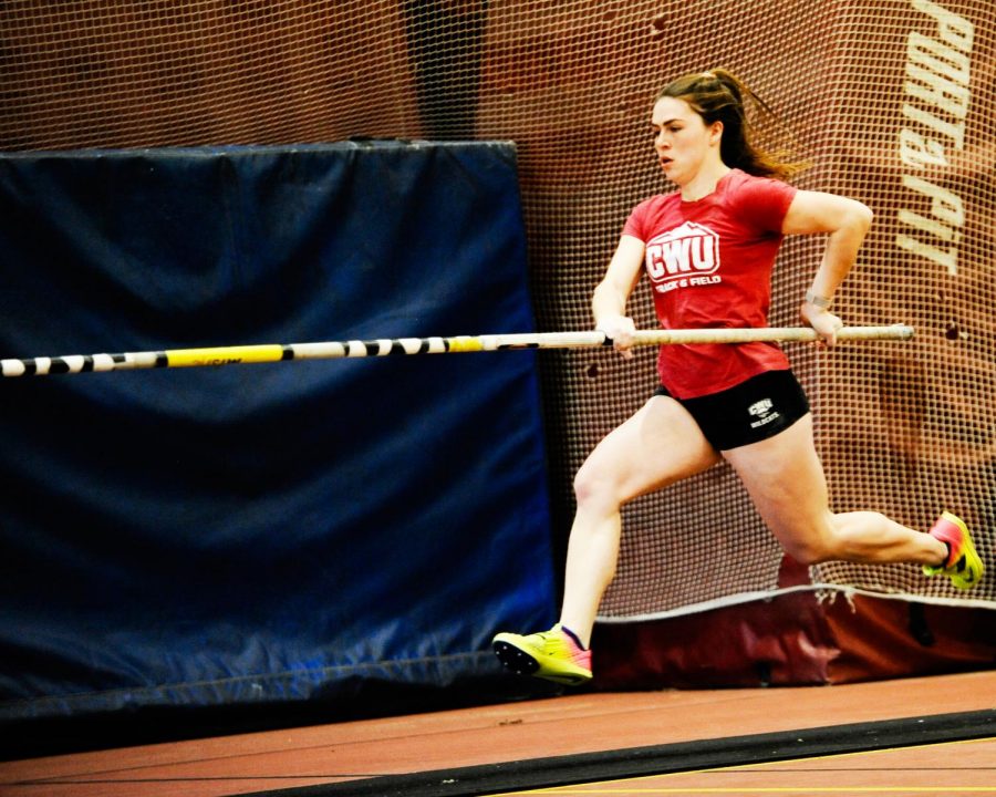Halle Irvine practices pole vault in the field house.