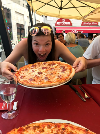Kate Caviezel, a young woman, eating pizza in Milan, Italy