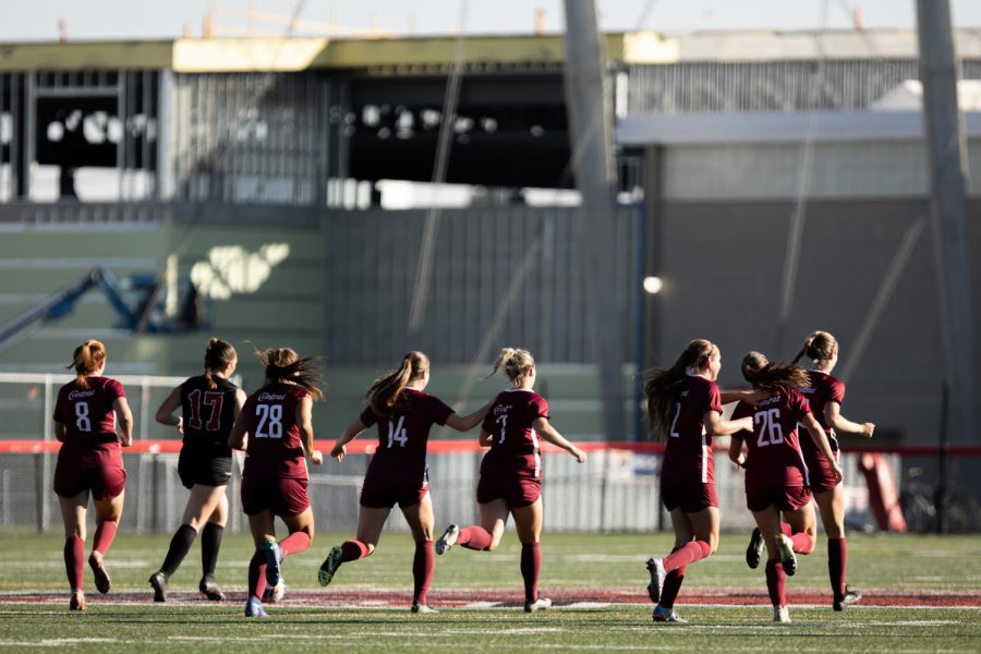 Womens soccer team running on field. Photo by Jacob Thompson _ Thompson Sports Photos