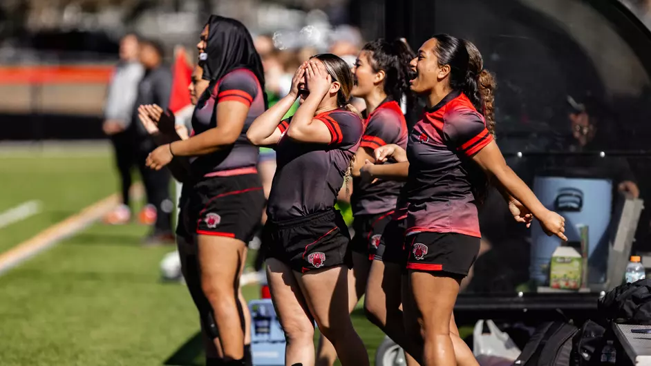 Team members cheering on the sideline. (Photo courtesy of Jacob Thompson Sports Media)