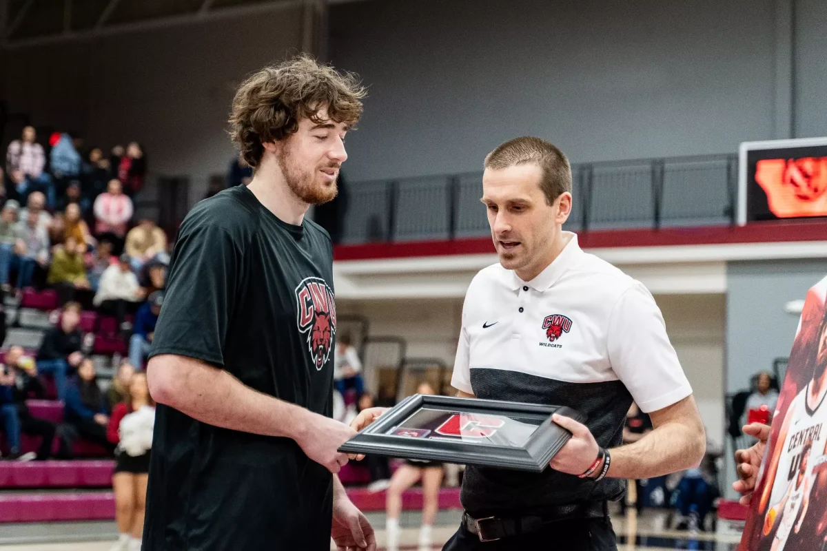 Brizee accepting senior award from Associate Head Coach Drew Church.